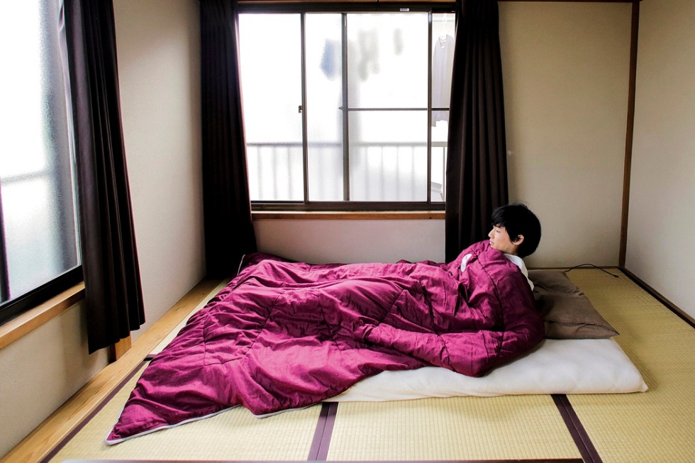 Minimalist Katsuya Toyoda demonstrates how he sleeps in his room in Tokyo, Japan, March 5, 2016. REUTERS/Thomas Peter SEARCH "MINIMALISM" FOR THIS STORY. SEARCH "THE WIDER IMAGE" FOR ALL STORIES - RTX2H2QQ